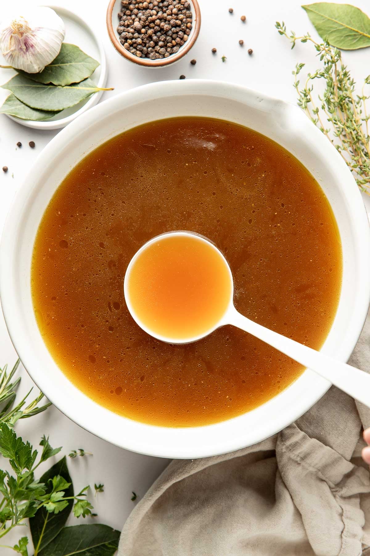 Overhead view of a bowl of bone broth with a spoon bringing up a spoonful. 