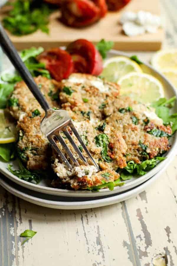 A fork getting a piece of a Quinoa Spinach Turkey Burger off of a plate