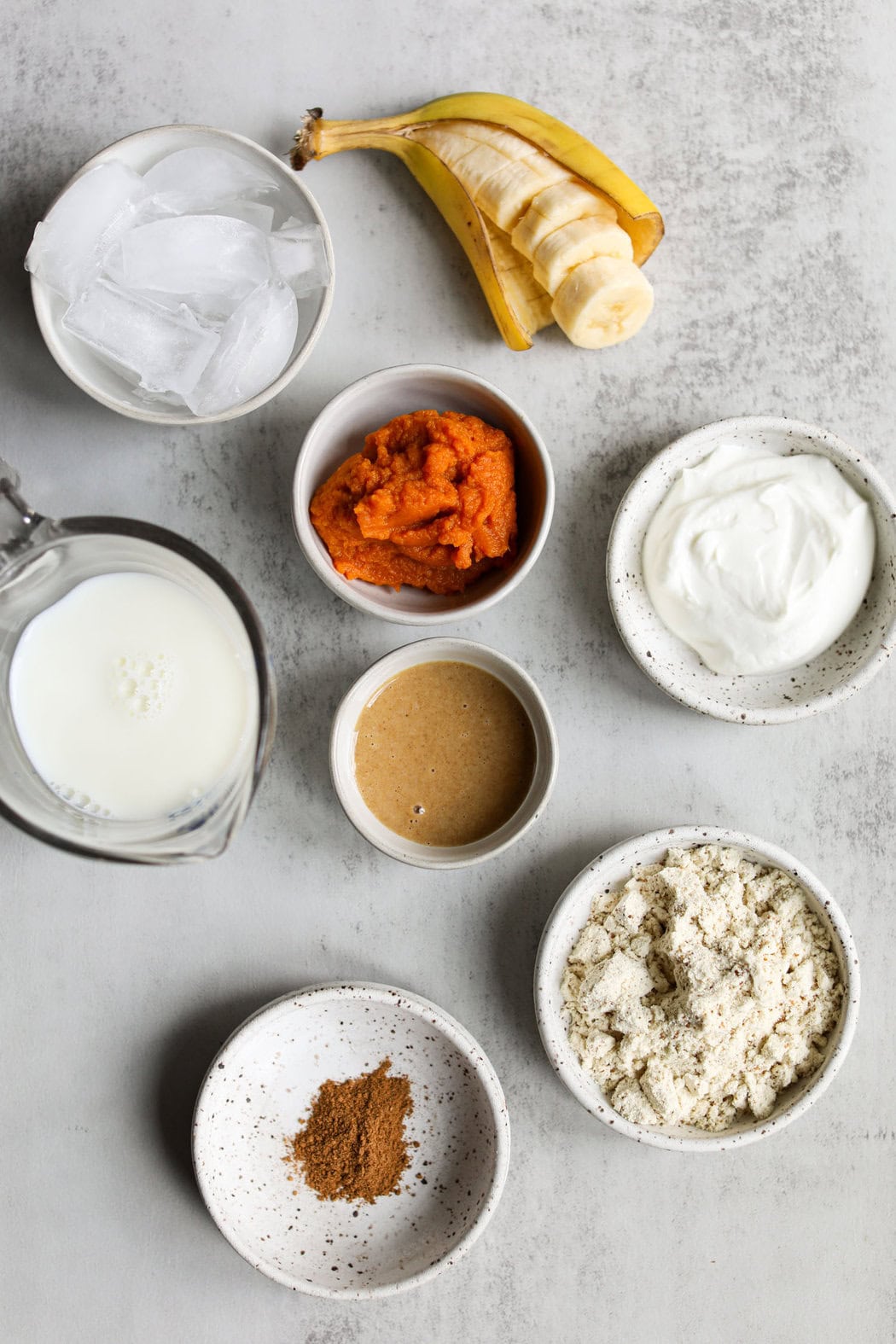 Overhead view of a variety of ingredients for a Protein Pumpkin Spice Smoothie. 