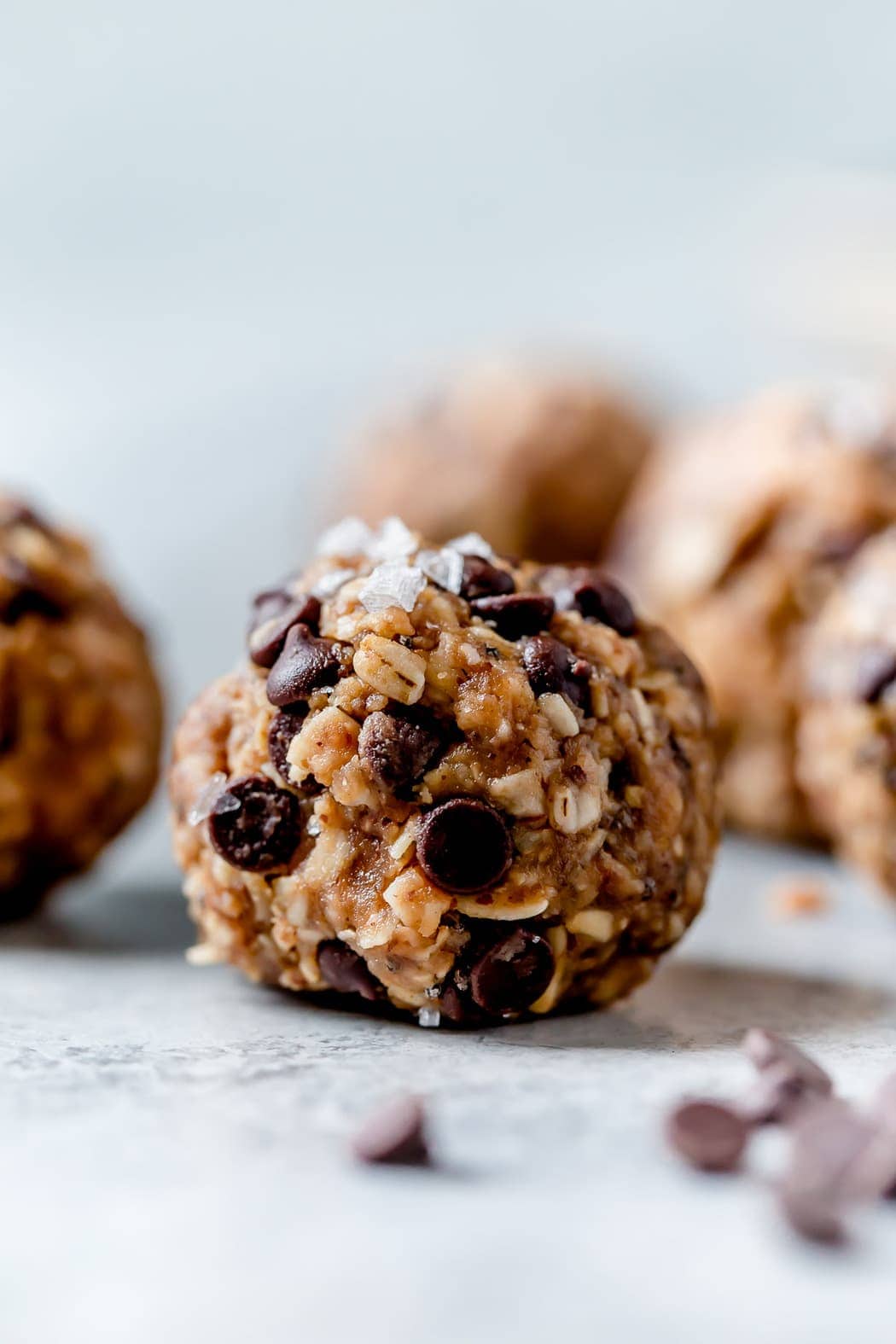 Peanut Butter Oatmeal Balls with chocolate chips studded in them and topped with flakes of sea salt.