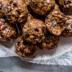A parchment covered serving platter piled high with chocolate chip peanut butter oatmeal energy bites