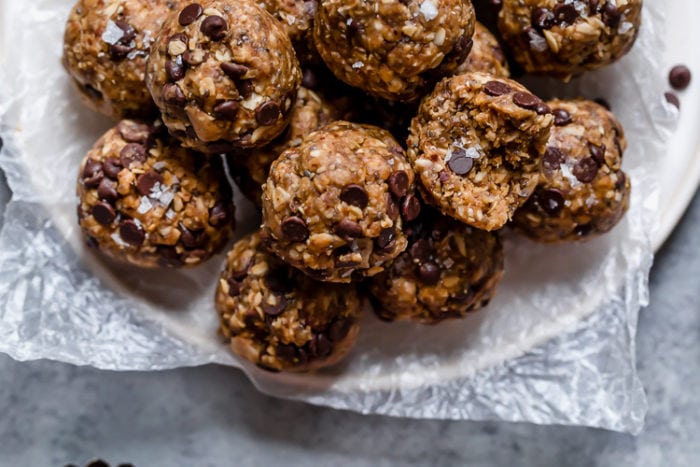 A parchment covered serving platter piled high with chocolate chip peanut butter oatmeal energy bites