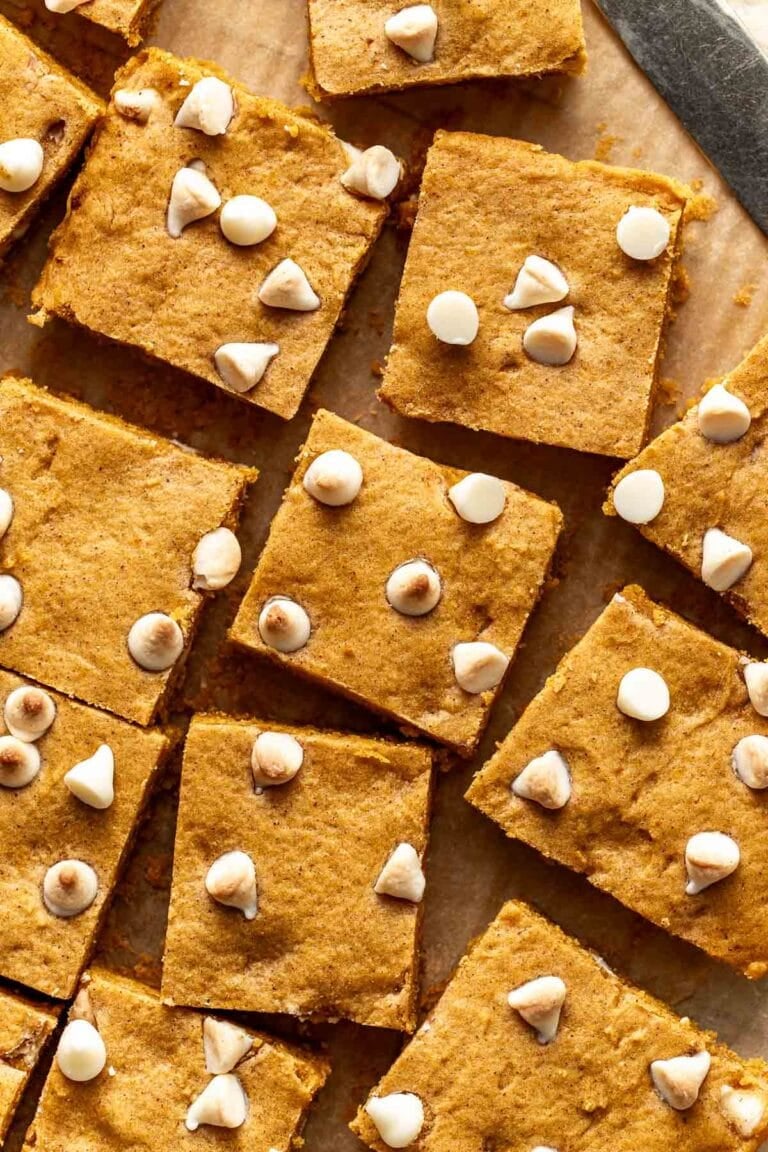 Overhead view pumpkin blondies topped with white chocolate chips cut into squares