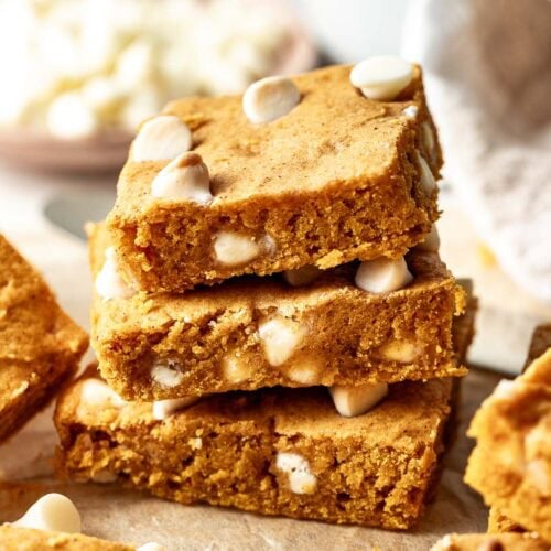 Close up view of a stack of Pumpkin Blondie squares studded with white chocolate chips.