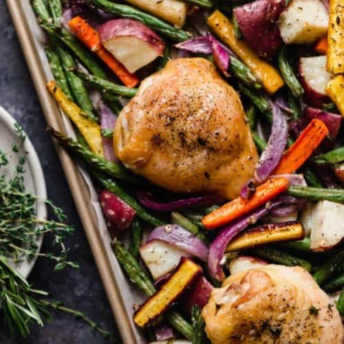 Overhead view sheet pan chicken thighs and vegetables.