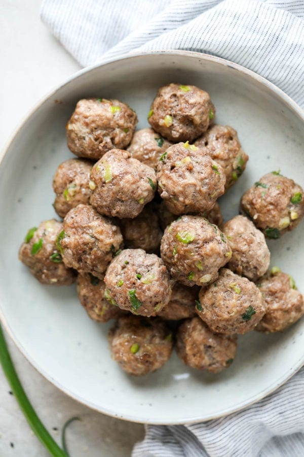Teriyaki meatballs perfectly cooked piled high in a speckled grey bowl