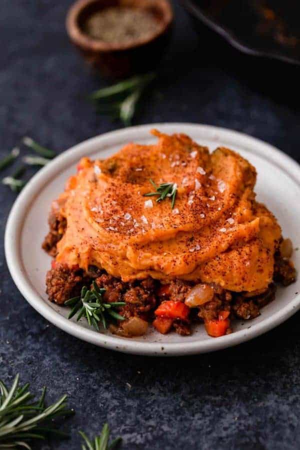 Hearty Sweet Potato Shepherd's Pie on a plate with sprigs of rosemary for garnish