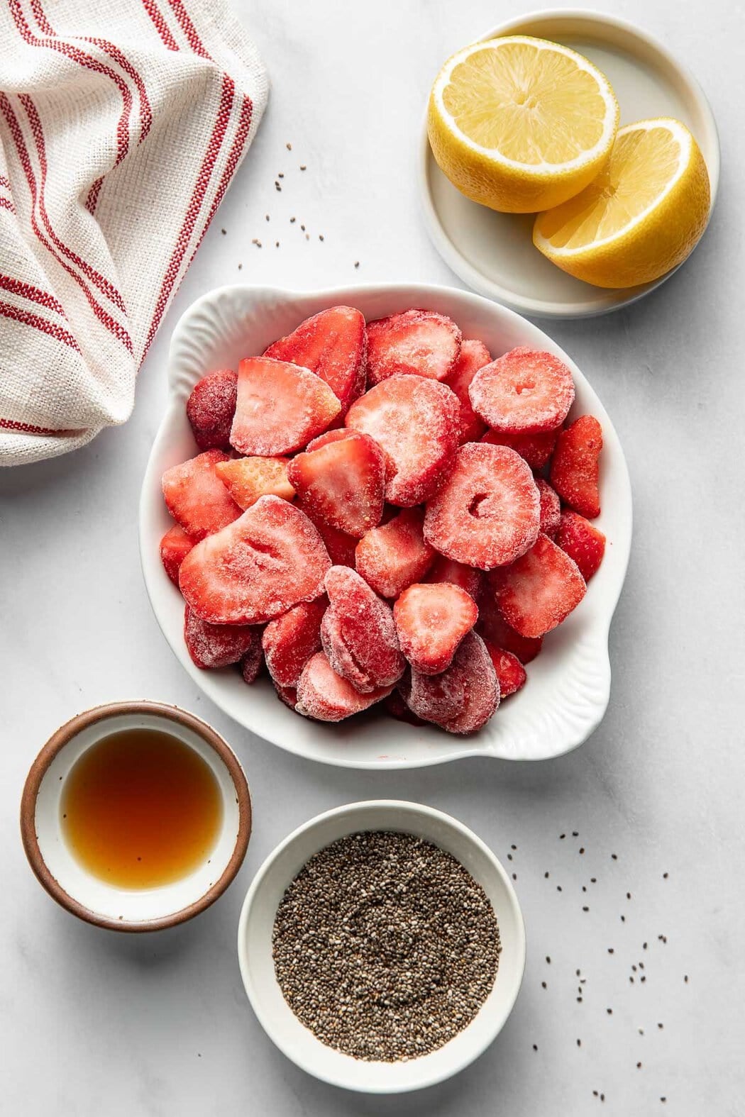 Overhead view of a variety of ingredients for Chia Seed Jam including frozen strawberries.
