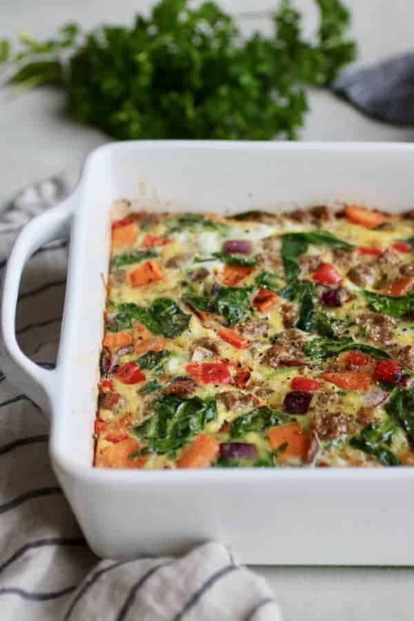 Egg bake with spinach and peppers in a white baking dish