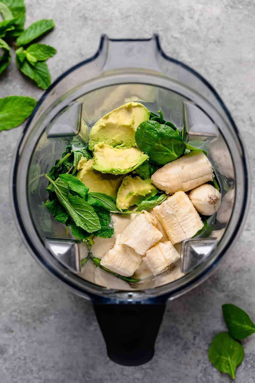 All ingredients for mint chocolate chip milkshake in a blender