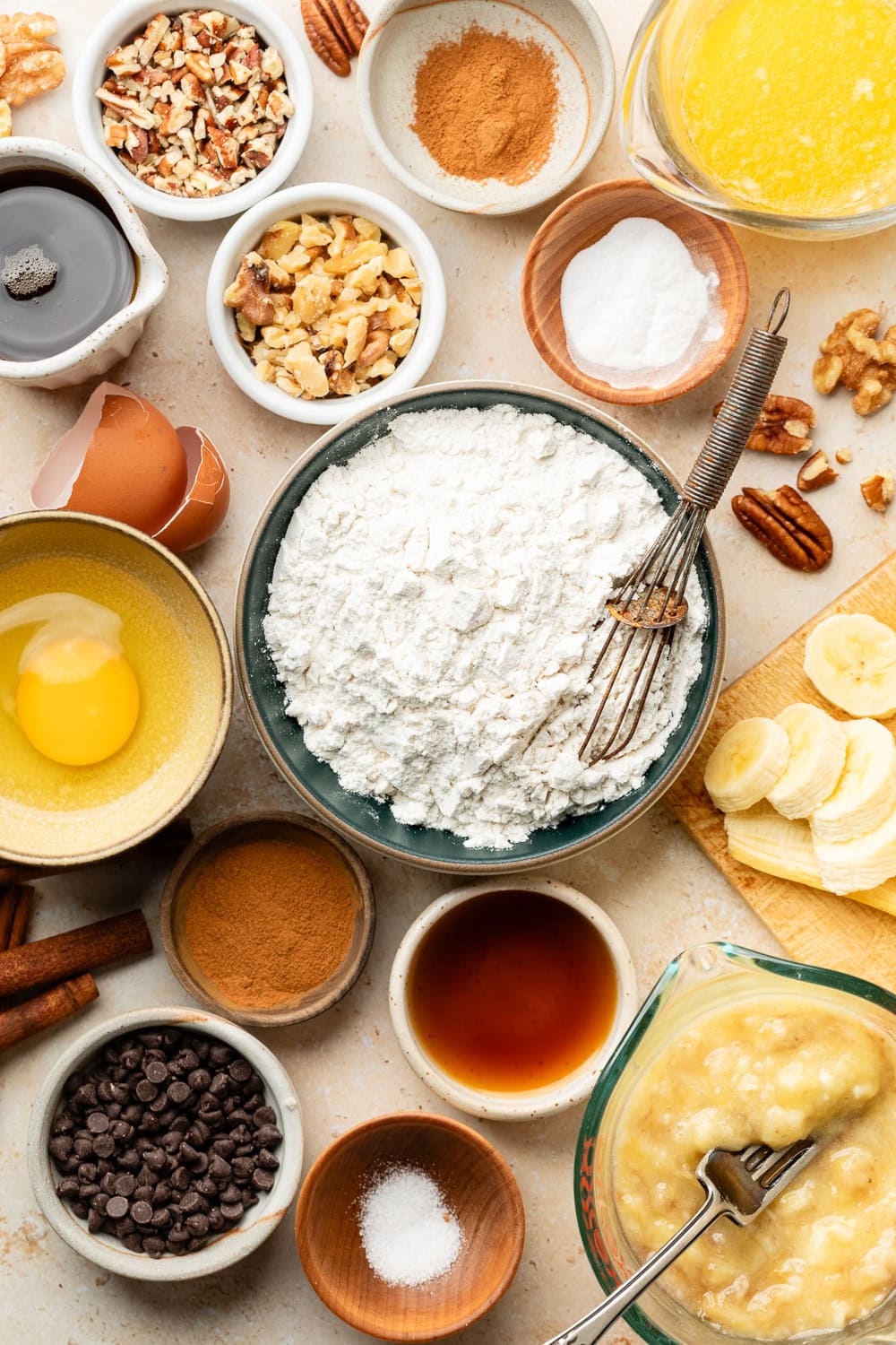 Overhead view of a variety of ingredients for Mini Banana Muffins in different sized bowls. 