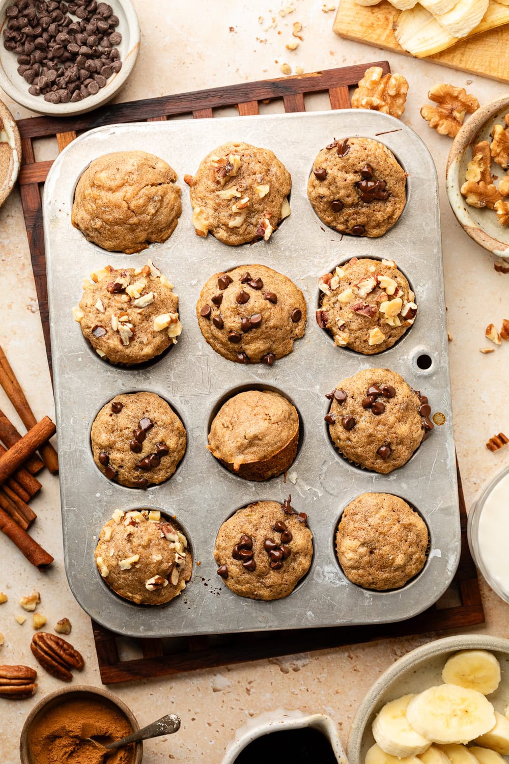 Overhead view of freshly baked Mini Banana Muffins topped with chocolate chips and pecan pieces. 