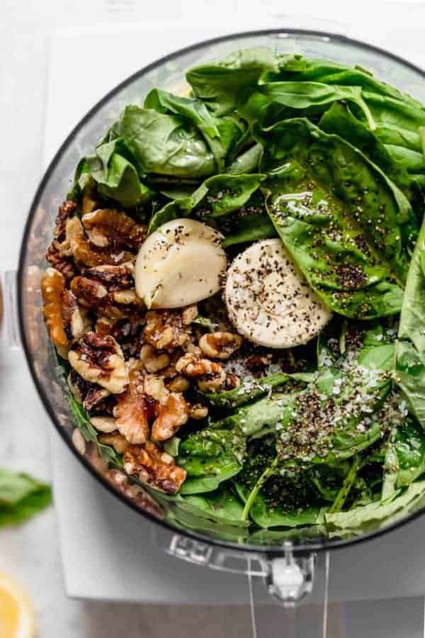 All ingredients for basil walnut pesto in a food processor