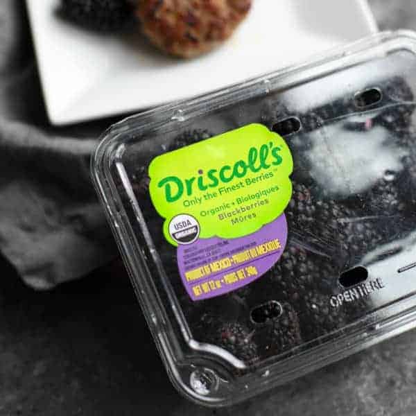 Driscoll's organic blackberries in front of a plate of Blackberry Sage Breakfast Sausage