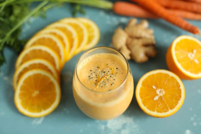 Overhead view of vibrant orange sunrise super smoothie topped with hemp hearts and filled with protein and antioxidants. 
