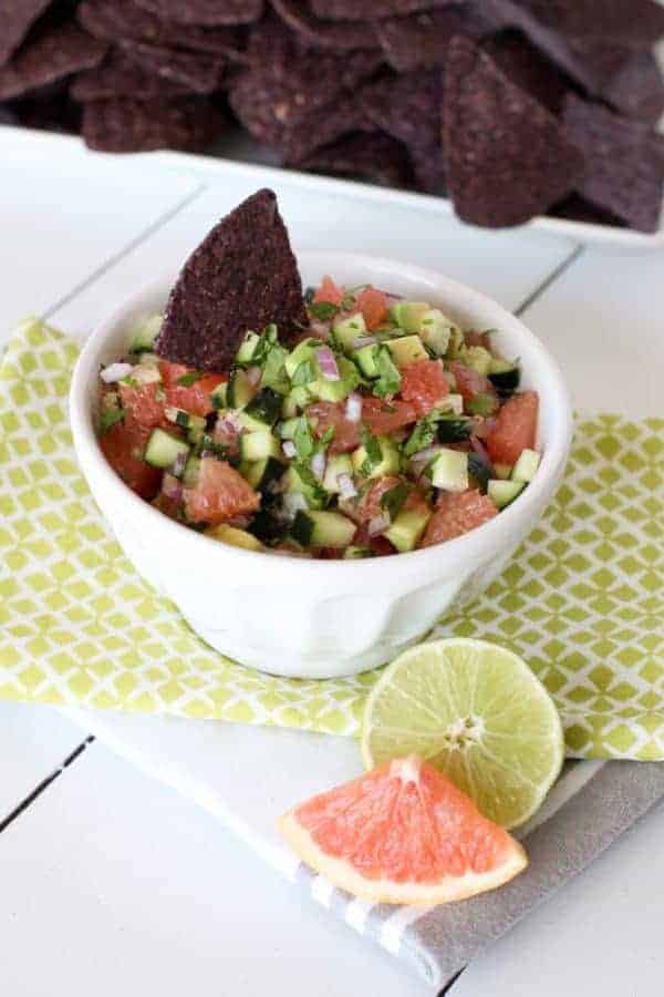 Grapefruit Avocado Salsa in a white bowl with a black tortilla chip