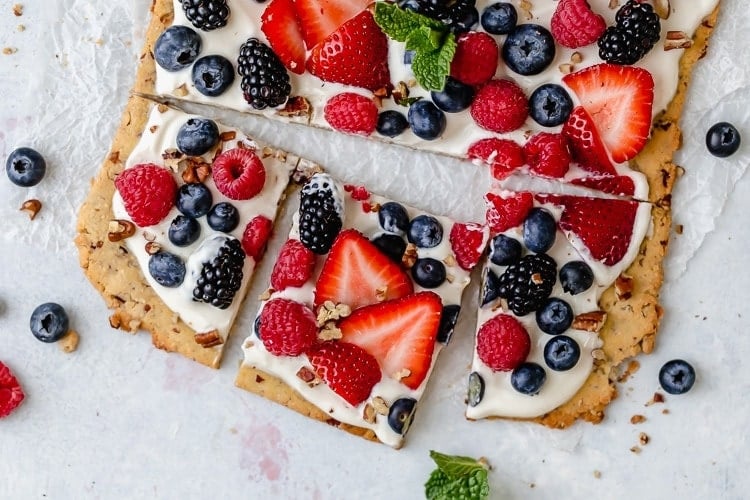 Overhead view berry fruit pizza cut into squares