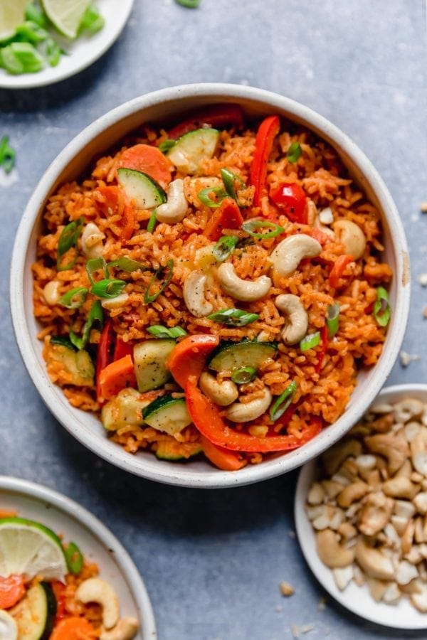 Overhead view of a shallow white bowl filled with veggie-studded Thai Coconut Curry Rice. 