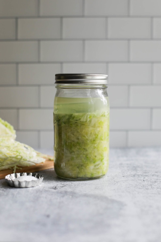 Homemade sauerkraut in a mason jar with the lid on.