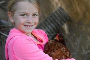 Girl with Buckeye Chicken | https://therealfooddietitians.com/10-great-reasons-to-keep-backyard-chickens/