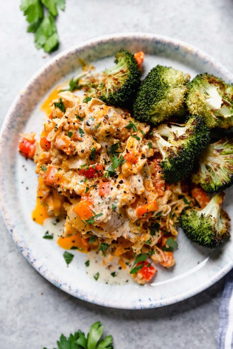 Overhead view of a plate of creamy buffalo chicken casserole with a side of broccoli. 