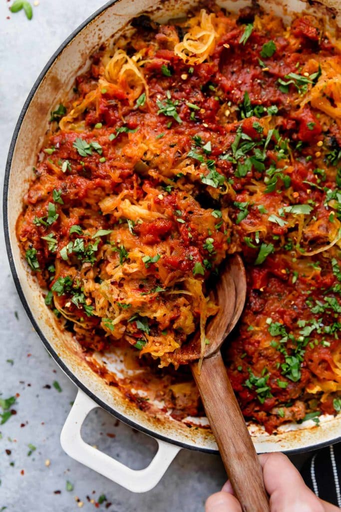 Grain-Free Spaghetti Pie in a Dutch Oven topped with fresh chopped basil.