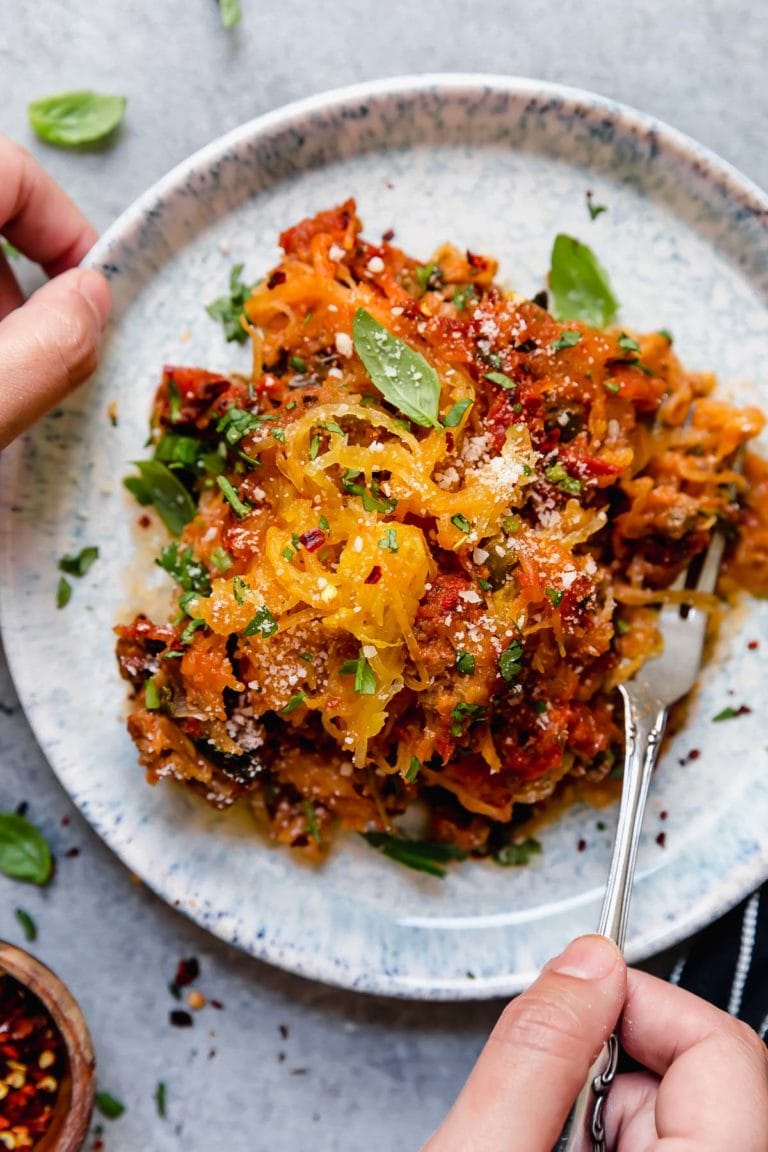 A plate of Grain-Free Spaghetti Pie topped with basil and parmesan cheese. 