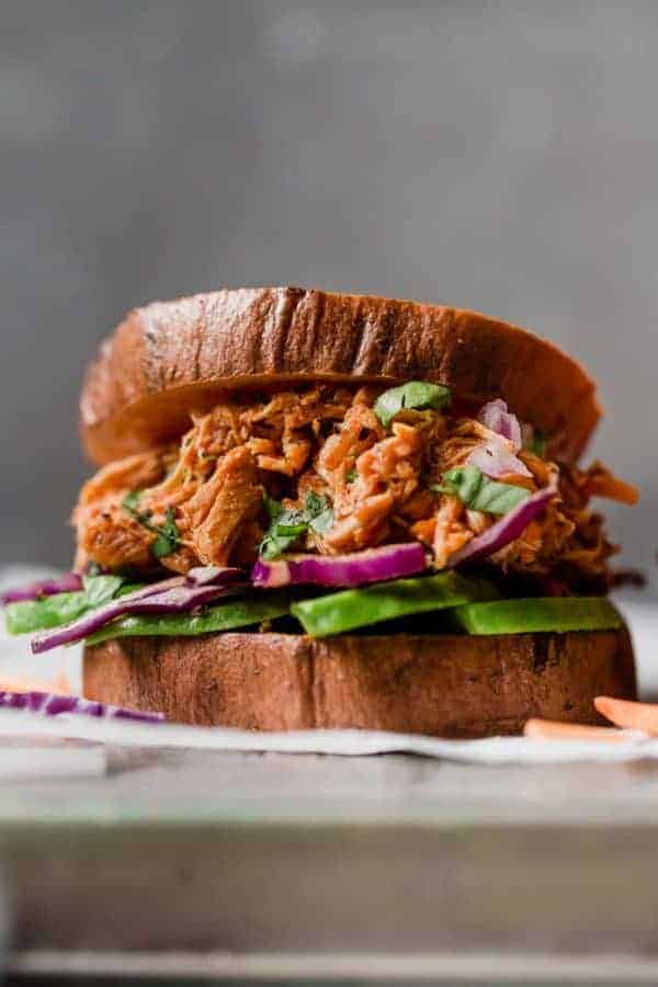Slow Cooker Chicken Sloppy Joe Sliders with avocado and red cabbage.