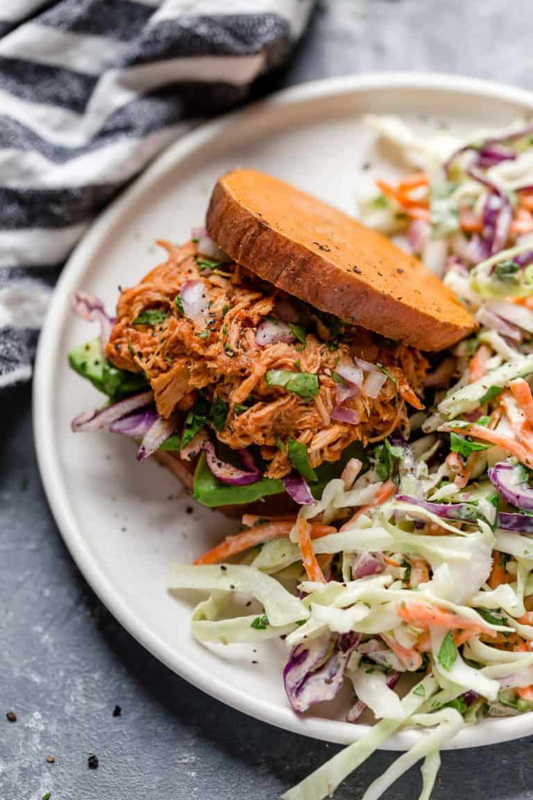 Close up view of Slow Cooker Chicken Sloppy Joe Sliders served inside 2 slices of sweet potatoes garnished with fresh coleslaw. 