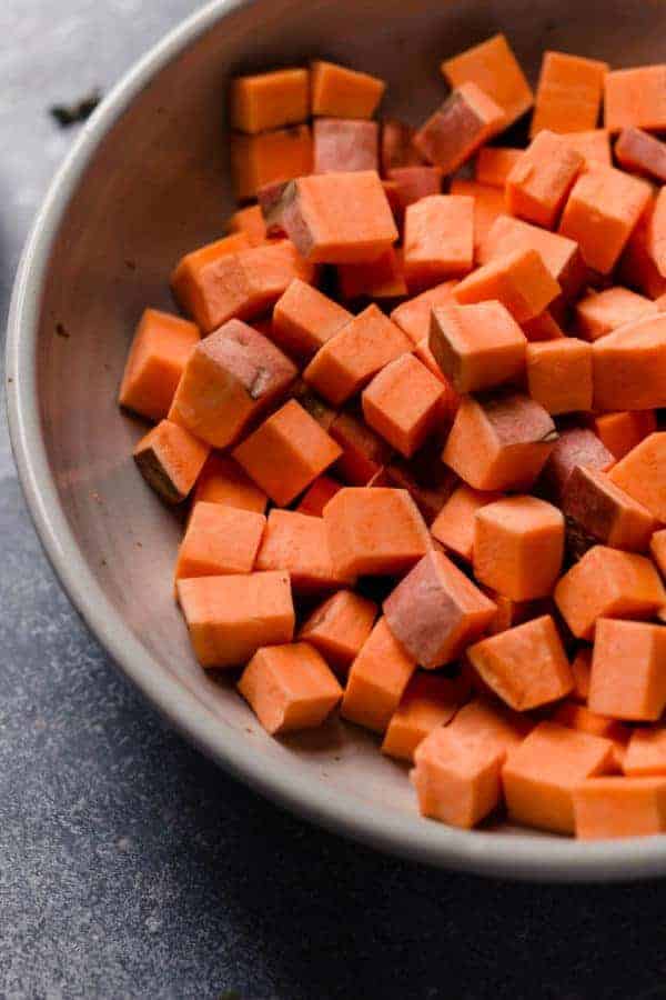 A side angle photo of a bowl with sweet Potato cubes in it for the Warm Chipotle Lime Sweet Potato Salad