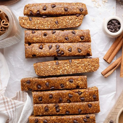 No-bake pumpkin protein bars topped with chocolate chips on a sheet of parchment paper.