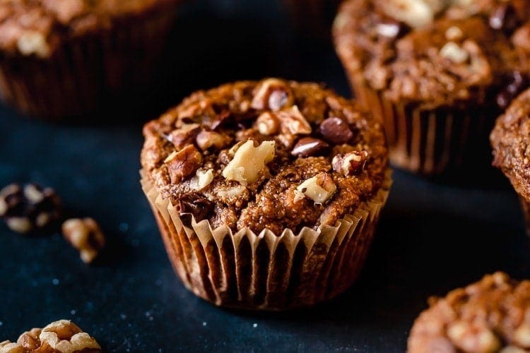 Close up view sweet potato banana nut muffin topped with walnuts