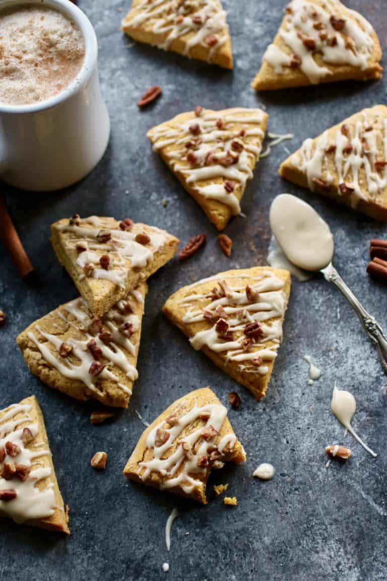 Overhead view of pumpkin spice scones topped with a glaze and chopped nuts. 