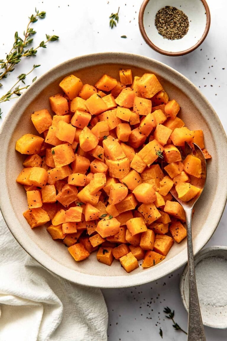 Overhead view of a bowl of Roasted Butternut Squash cubes perfectly crisp and seasoned.