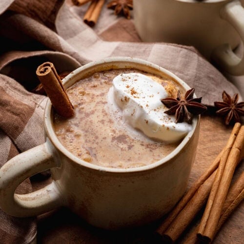 A pumpkin chai latte with a cinnamon stick sticking out.