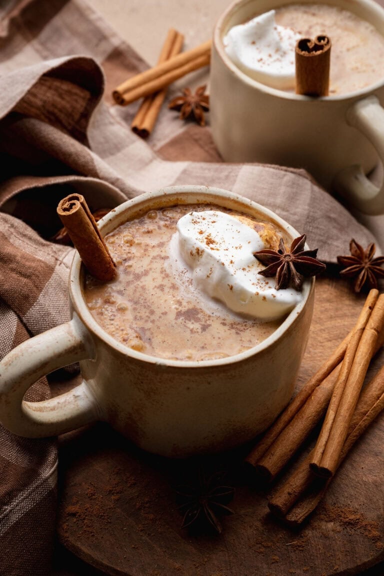 A pumpkin chai latte with a cinnamon stick sticking out.
