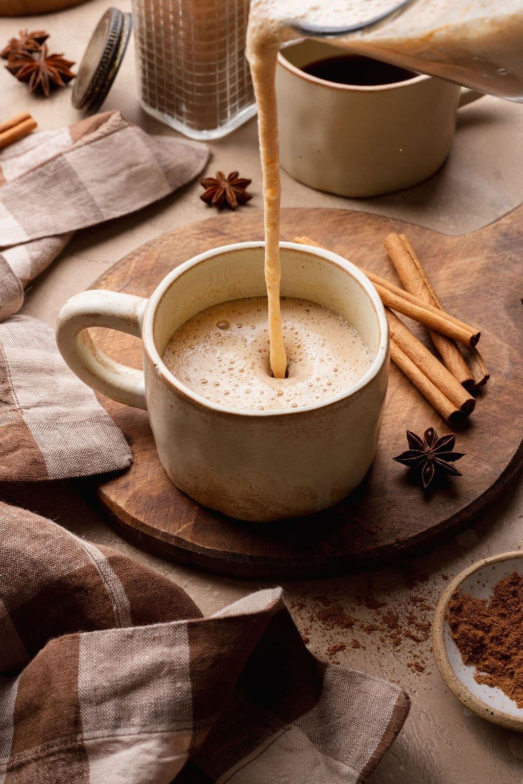 A frothed pumpkin chai latte being poured into a mug. 