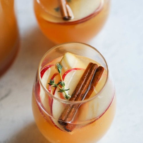 Apple Sangria in small glasses with cinnamon sticks for a Thanksgiving Menu