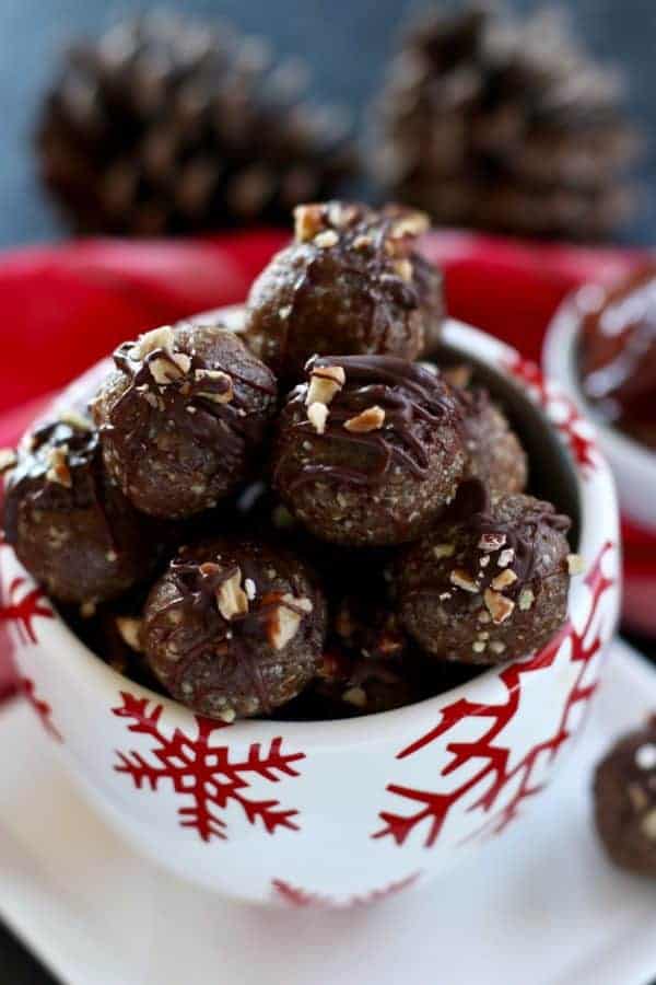Close up view of pecan pie truffles in a white and red snowflake bowl