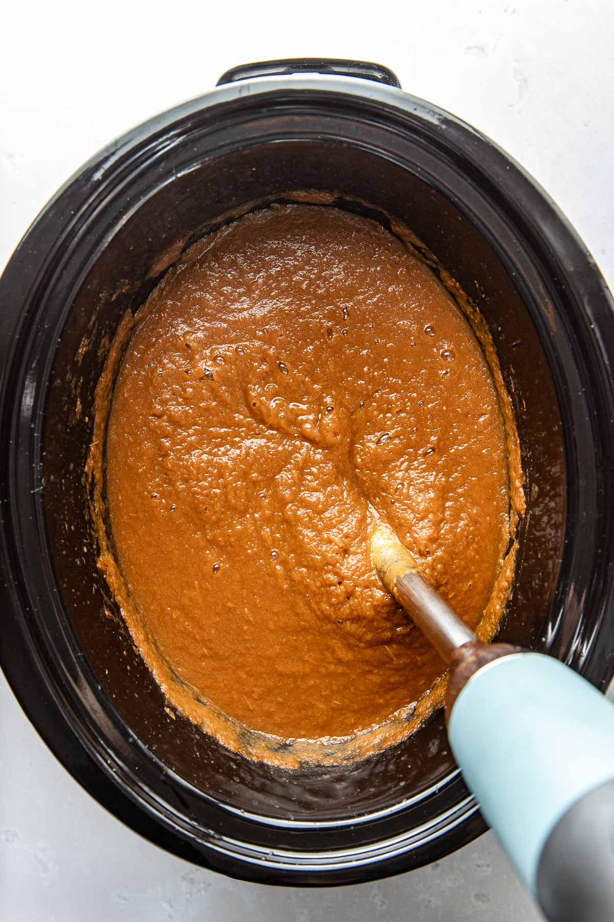 Overhead view of a slow cooker filled with freshly blended Crockpot Pumpkin Applesauce