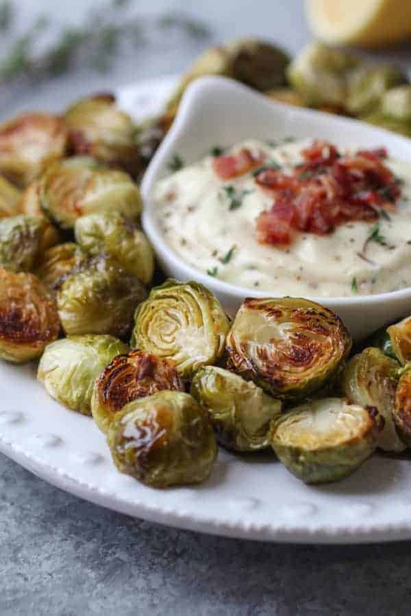 Roasted Brussels Sprouts with Bacon Aioli on a white plate