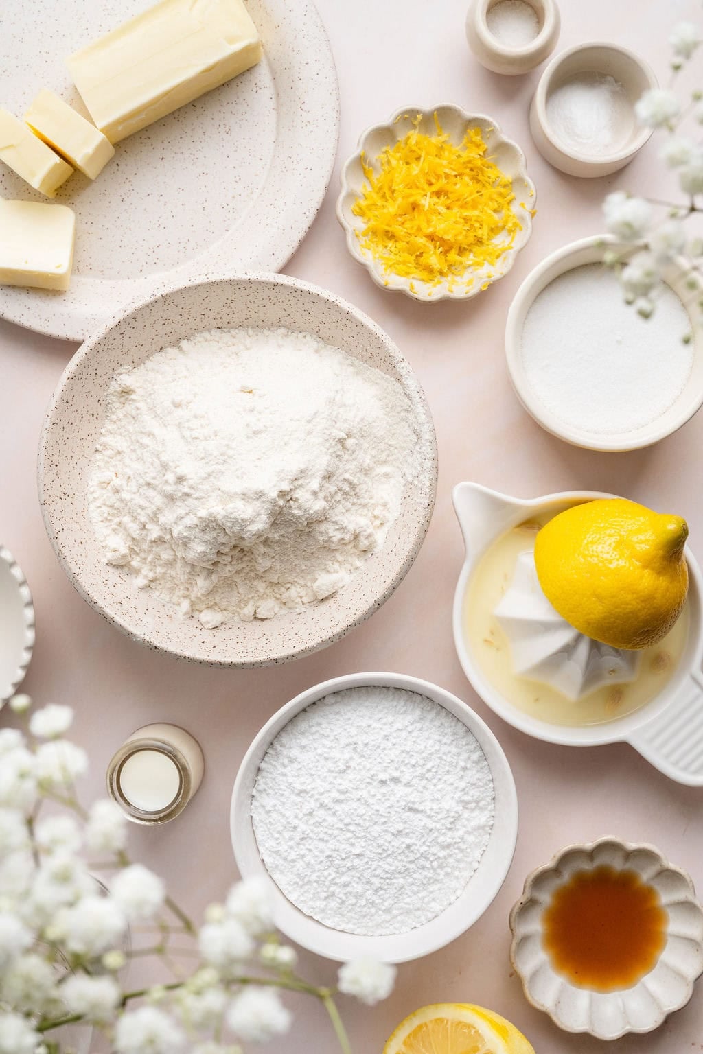 Overhead view of a variety of ingredients for Lemon Cookies in different sized bowls. 