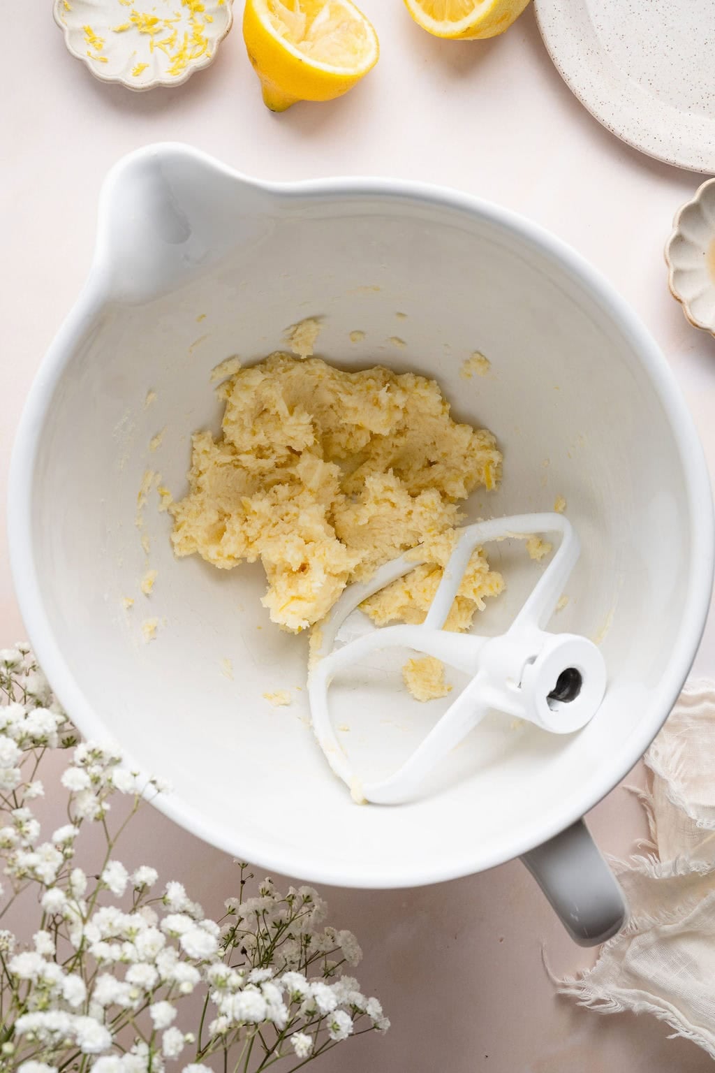Overhead view of a white mixing bowl filled with lemon cookie dough. 