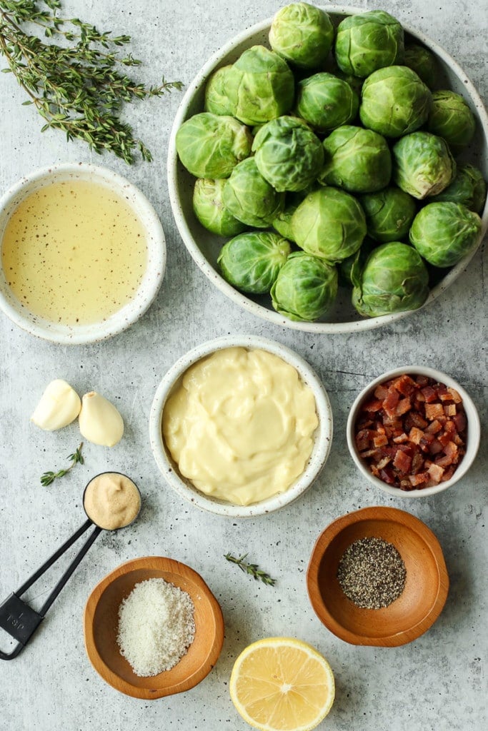 All ingredients for Roasted Brussels Sprouts and Garlic-Bacon Aioli arranged together in small bowls and measuring spoons.