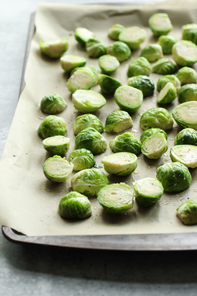 Brussels sprouts arranged on a parchment-lined baking sheet.
