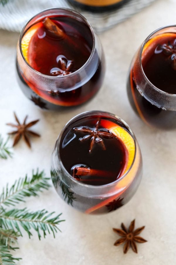 overhead shot of mulled wine in glasses with orange slices and cinnamon sticks