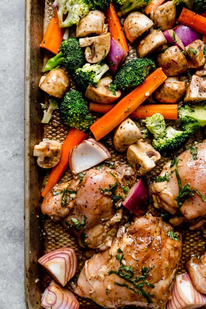 Chicken and veggies on a pan prepared for baking 
