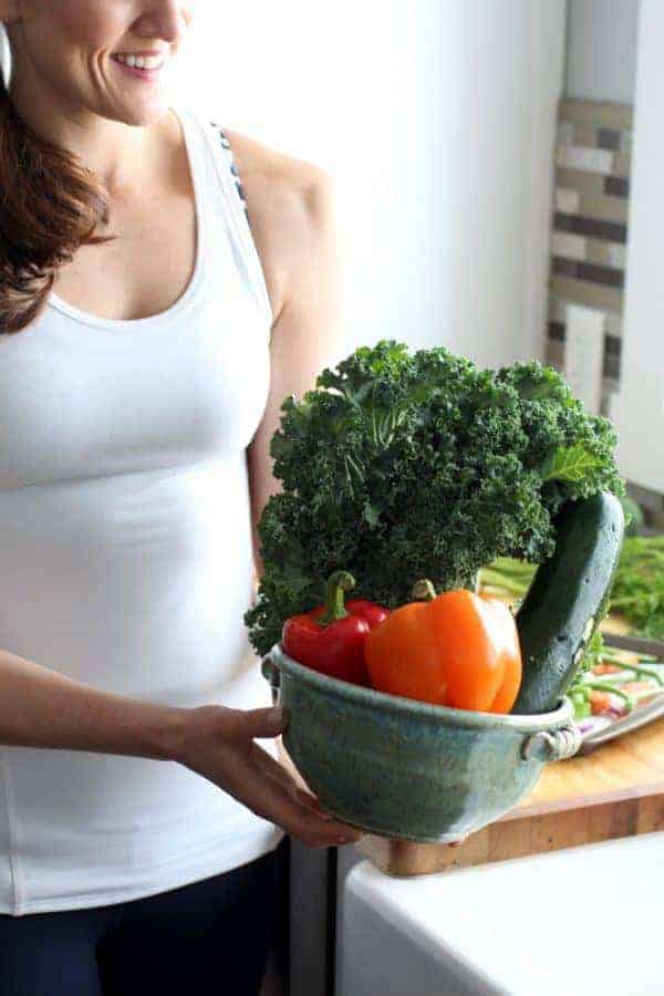 woman standing with veggies in a bowl