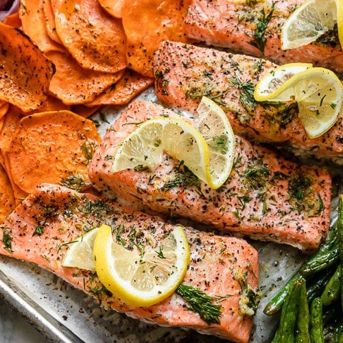 A close view of salmon and sweet potato rounds on a sheet pan