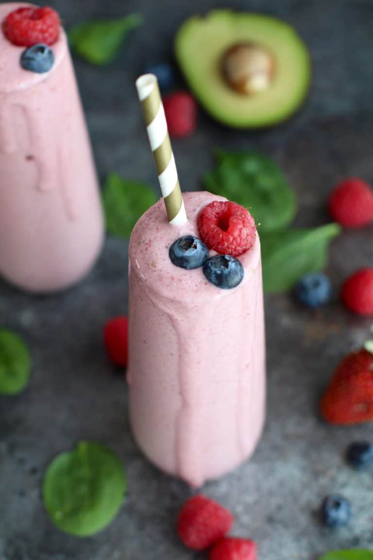 Two banana berry smoothies topped with berries. 